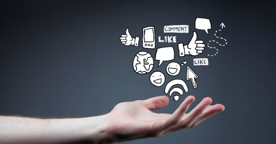 hand holding social media emblems